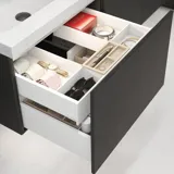 Stylish bathroom inspiration with beige vanity unit with inner drawer, upper cabinet, open shelf, oval mirror with lighting, matching pendants, shelf under the mirror, and wall-mounted toilet. Walls with light, elongated tiles.