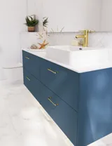 Bathroom inspiration with bathroom furniture in modern blue colour, elegant countertop basin and large square mirror with light, white herringbone tiles create a stylish and classic look