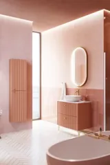 Large vintage retro bathroom inspiration with a terracotta-colored grooved vanity, elegant thin countertop with a beautiful vessel sink, stylish oval mirror with brass edge. Pink tiles and grey herringbone tiles give a romantic and feminine look