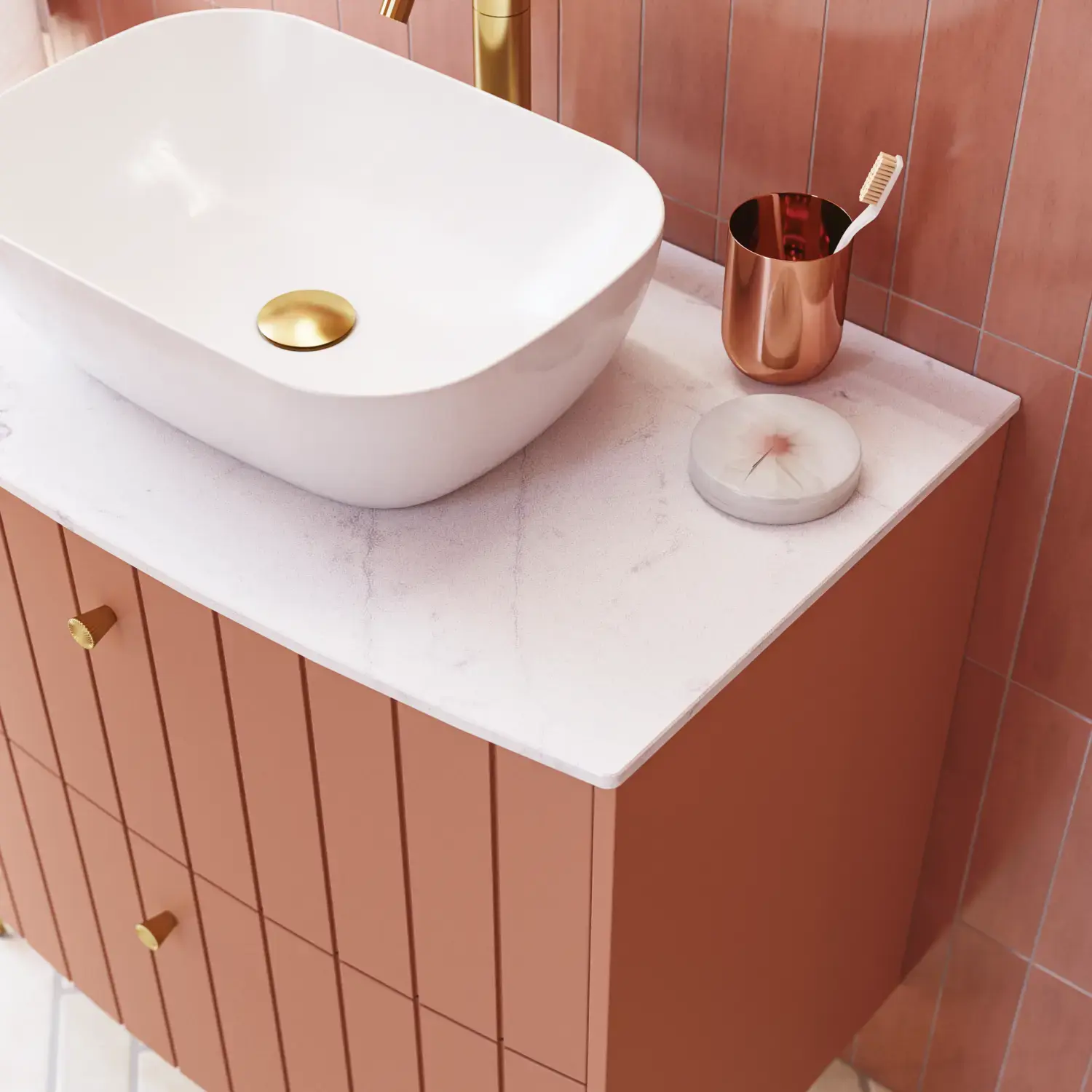 Large vintage retro bathroom inspiration with a terracotta-colored grooved vanity, elegant thin countertop with a beautiful vessel sink, stylish oval mirror with brass edge. Pink tiles and grey herringbone tiles give a romantic and feminine look