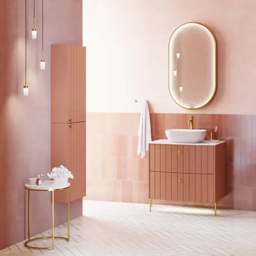 Large vintage retro bathroom inspiration with a terracotta-colored grooved vanity, elegant thin countertop with a beautiful vessel sink, stylish oval mirror with brass edge. Pink tiles and grey herringbone tiles give a romantic and feminine look