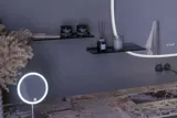 Large bathroom inspiration with grey vanity unit with integrated handle, stylish side-mounted sink, square mirror with rounded corners, concrete-look walls and raw materials for an urban look