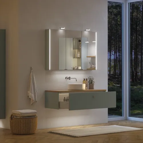 Large bathroom inspiration in Nordic style with bathroom furniture in light blue colour and wooden countertop with elegant countertop basin, herringbone wooden floor creating a bright and classic style