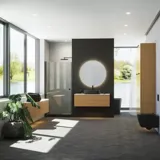 Minimalist and sleek bathroom inspiration with vanity unit, base cabinets, and tall cabinets in golden oak, large round mirror with light control, colored toilet, and countertop sink