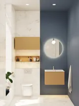 Small, stylish bathroom with dark blue walls, soft yellow bathroom furniture with grooves, and an elegant round mirror with lamp