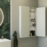 Stylish and luxurious bathroom with gentle green tones, a large elegant round mirror, and a modern, sophisticated green toilet