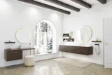 Nordic style bathroom inspiration with vanity unit and base cabinets in smoked oak, makeup area, side-mounted sink, round mirror with brass frame, and visible charming wooden beams