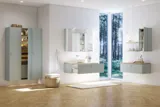 Large bathroom inspiration in Nordic style with bathroom furniture in light blue colour and wooden countertop with elegant countertop basin, herringbone wooden floor creating a bright and classic style