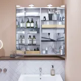 Small bathroom inspiration with a washbasin cabinet in a special color, mirror cabinet with lights, decorative mirrors with tinted glass shelf, white herringbone tiles give a sleek and classic look.