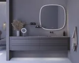 Large bathroom inspiration with grey vanity unit with integrated handle, stylish side-mounted sink, square mirror with rounded corners, concrete-look walls and raw materials for an urban look