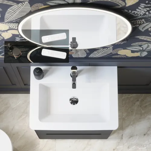 Bathroom inspiration with dark blue wall panels, romantic floral wallpaper, dark blue vanity with soft curves, and a beautiful round mirror with light, creating a vintage look
