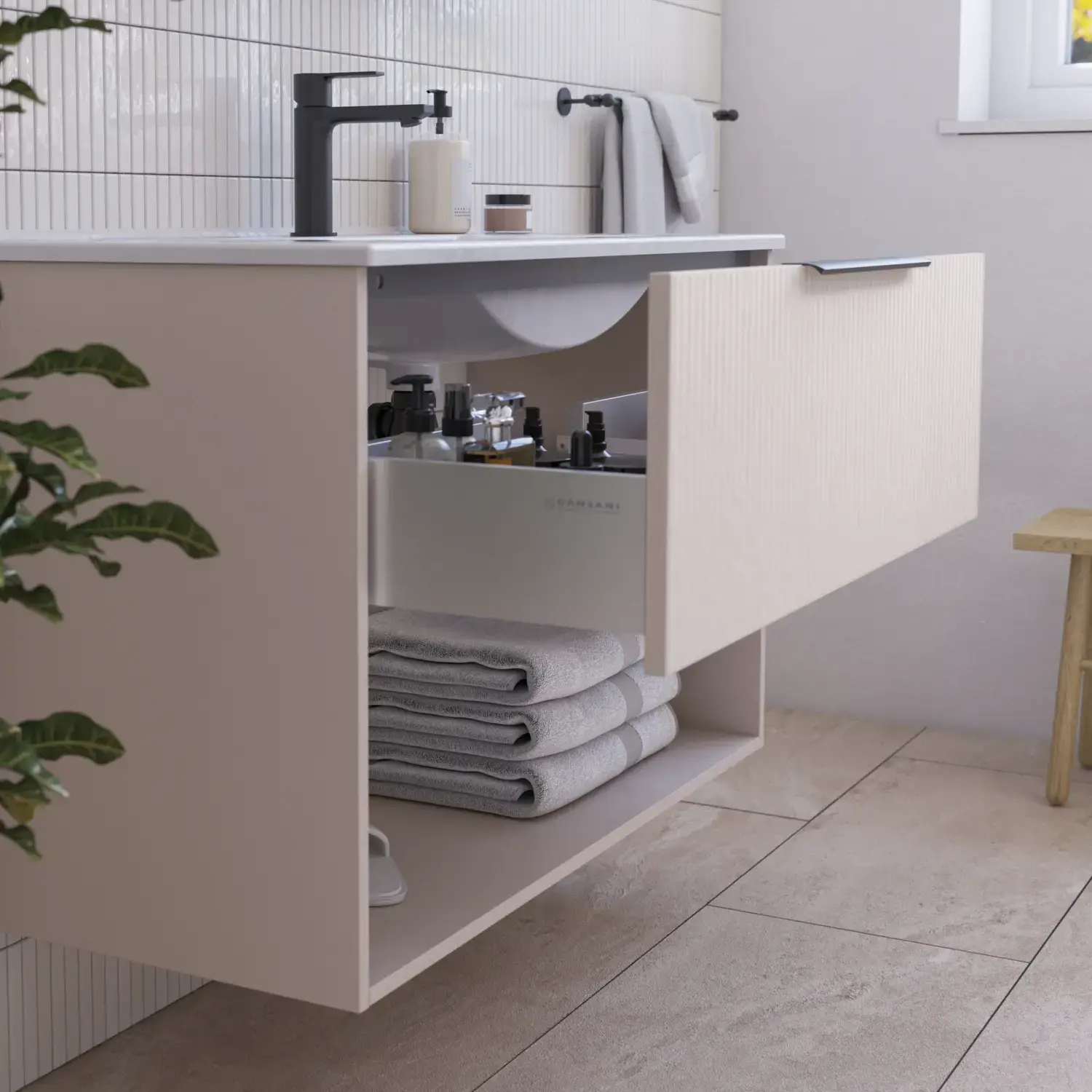 Bathroom inspiration with pink vanity unit with elegant grooves and beautiful sink, white tiles on the walls and large beige tiles on the floor create a romantic and feminine look.