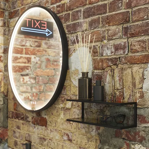 Raw and modern bathroom in an urban style. Beautiful vanity units and black framed round mirrors
