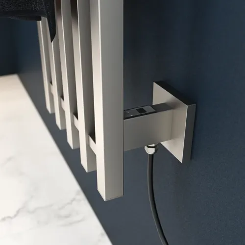 Electric towel rail on a dark blue wall in a stylish bathroom.