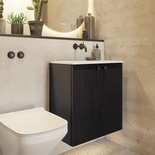 Bathroom inspiration with a black oak washbasin cabinet, an elegant round mirror and sink, stylish accessories, cactus plants, and walls in raw materials give a rough, industrial, and urban look.