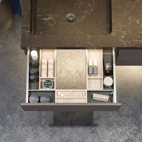 Stylish and spacious bathroom inspiration with a large round mirror with a black frame, dark stone sink, colored toilet, upper cabinet, and open shelf in a sophisticated and muted design.