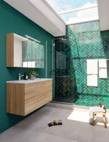 Large bathroom inspiration with a vanity unit in Warm Oak, elegant double sink, beautiful mirror cabinet and shower screen, green herringbone tiles for a sophisticated look.