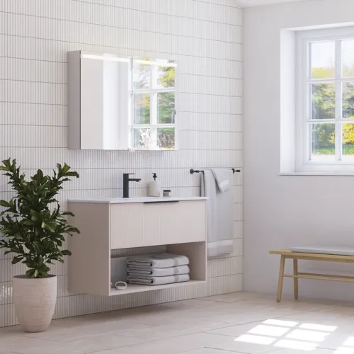 Large bathroom inspiration with small oblong tiles, elegant vanity unit and tall cabinet in light beige with beautiful narrow stripes, black modern elongated handles and stylish mirror cabinet with light to create a romantic atmosphere.