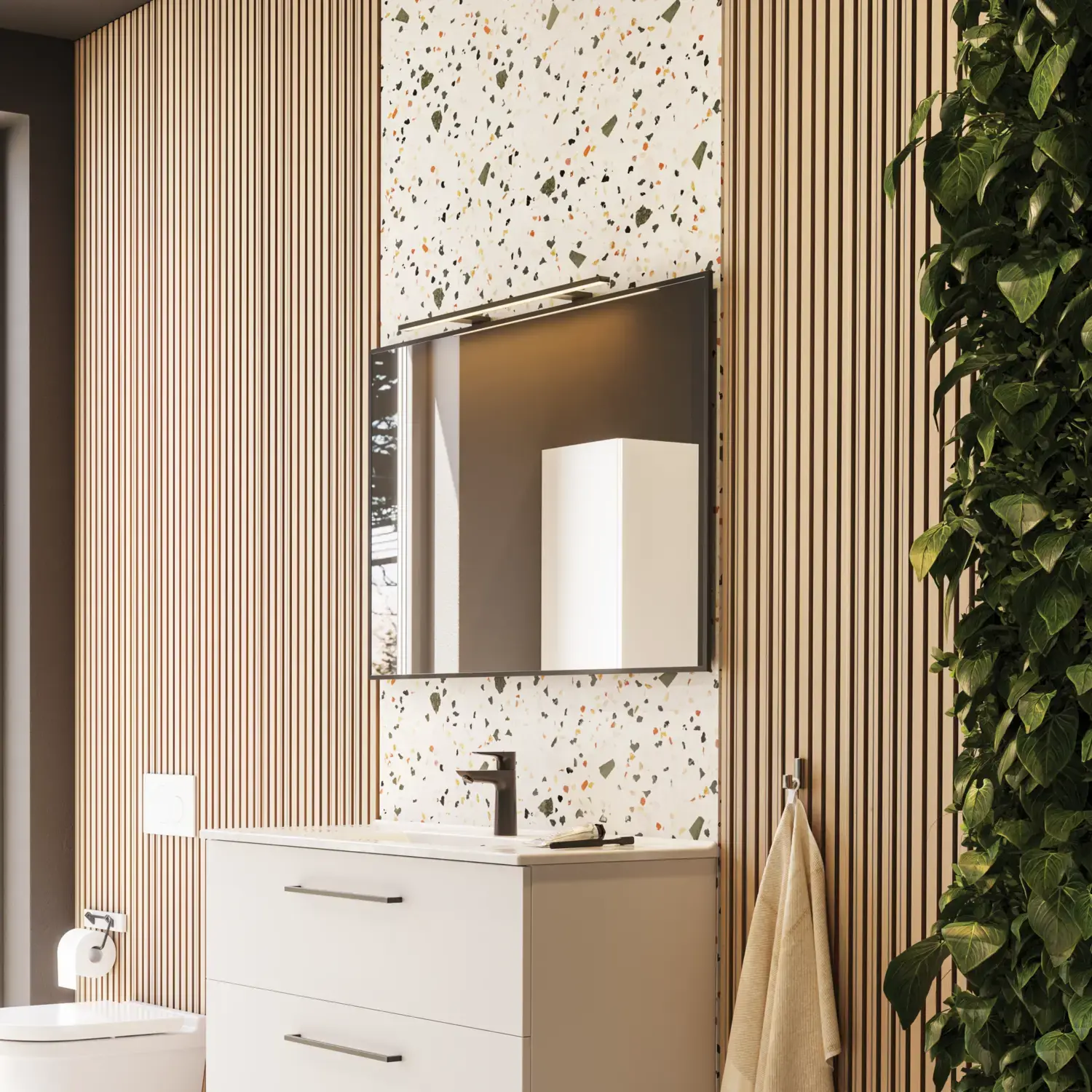 Large bathroom inspiration with bathroom furniture in matt white with elegant washbasin and square mirror with black rim and lamp, terrazzo wall and floor and plants on the wall for a modern and sophisticated look.