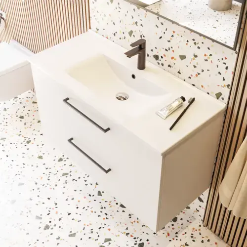 Large bathroom inspiration with bathroom furniture in matt white with elegant washbasin and square mirror with black rim and lamp, terrazzo wall and floor and plants on the wall for a modern and sophisticated look.
