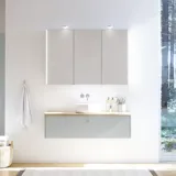 Large bathroom inspiration in Nordic style with bathroom furniture in light blue colour and wooden countertop with elegant countertop basin, herringbone wooden floor creating a bright and classic style